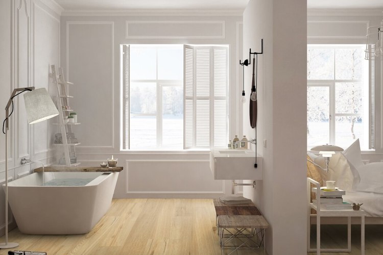 Salle de bains ouverte avec baignoire îlot posée sur un sol PVC imitation bois clair, fenêtres à volets battants