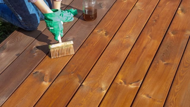 Application d un saturateur à la brosse sur une terrasse en bois
