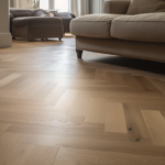 Salon moderne avec canapé gris, fauteuils bleus et sol en bois à chevrons