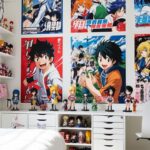Chambre d'adolescent avec un style manga, des posters d'animés encadrés, des figurines de collection sur des étagères et un bureau avec un ordinateur et une tablette graphique.