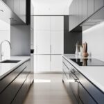 Une cuisine moderne est présentée. Des armoires noires et blanches sont disposées de chaque côté d'un sol clair. Un four encastré est visible. Le plan de travail est propre et épuré. L'espace est lumineux et minimaliste.