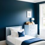 Un lit bleu clair, recouvert d'une couette blanche et d'un jeté bleu marine, repose dans une chambre aux murs bleu foncé. Une commode bleue claire est placée près d'une fenêtre. L'ambiance est calme et sereine.