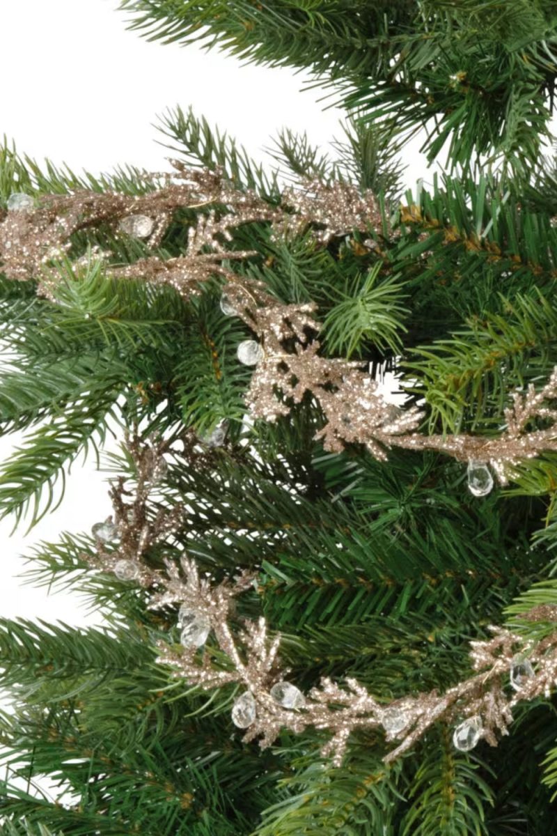 Un sapin de Noël vert est décoré d'une guirlande pailletée couleur bronze et de fausses gouttes de rosée transparentes. L'ensemble donne un effet festif et scintillant.